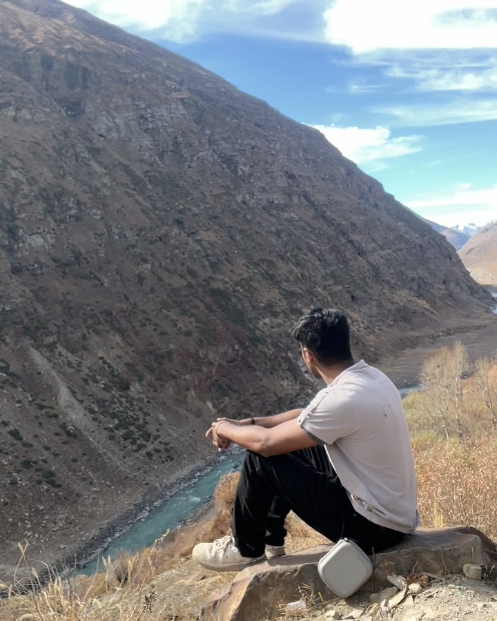 A reflective moment beside a river in Himachal